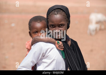 Eine indigene Mandingo (mandinka) Mädchen mit einem Jungen in einem Dorf in Gambia, Westafrika. Stockfoto