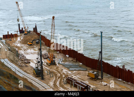Bau der Promenade am Meer, Stärkung der Küste, spezielle Ausrüstung am Strand Stockfoto