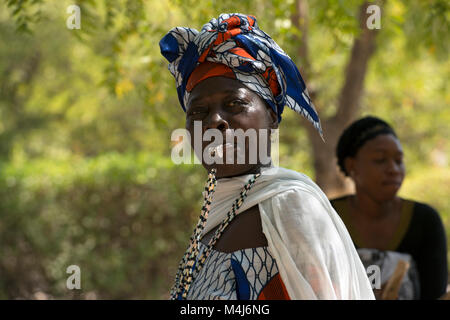 Eine ehtnic Mandinka (Mandingo) Stamm Frau weht ein Pfeifen, während eine traditionelle Musik und Tanz Performance, Bintang, Gambia, Westafrika. Stockfoto