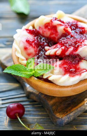 Knödel mit Kirschen und Beeren Sauce. Stockfoto