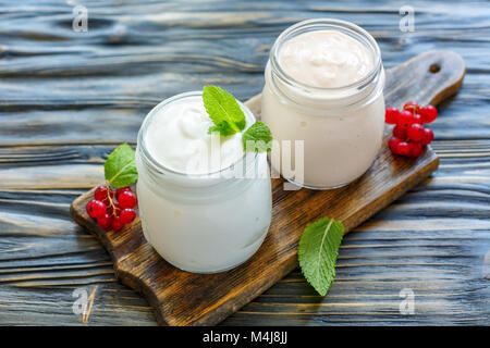 Joghurt und saure gebackene Milch in Töpfen. Stockfoto