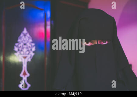 Arabische Frau in bescheidenen schwarze Kleidung mit Gesicht bedeckt mit schwarzem Niqab Stockfoto