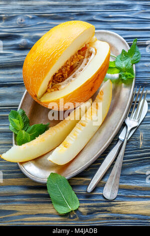 Gelbe Melonen geschnitten auf dem Metallauflagefach aus. Stockfoto