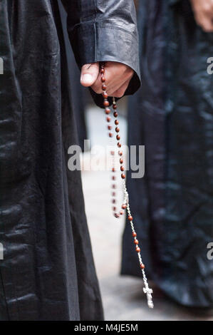 Detail der Hand des Pönitenten mit einem Rosenkranz, zählen die Perlen beim Beten. Stockfoto