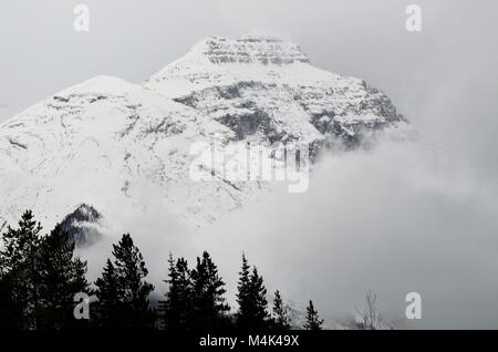 Die schneebedeckten Berge in der Ferne sitzt, mit einem Bett von Nebel, Stockfoto