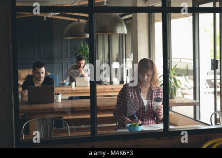 Geschäftsfrau schreiben auf ein Tagebuch in der Cafeteria Stockfoto