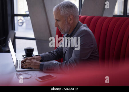 Geschäftsmann mit Laptop in der Lobby Stockfoto
