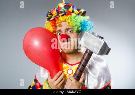 Clown mit einem Hammer grauen Hintergrund isoliert Stockfoto