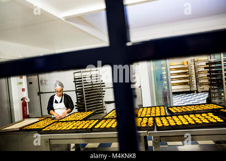 Eine Frau Vorbereitung Pastel de nata in der Küche auf pasteis de belem in Lissabon, Portugal. Stockfoto