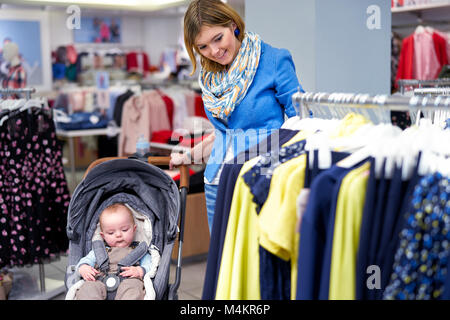 Junge Frau wählt Kleidung in einem Geschäft Stockfoto