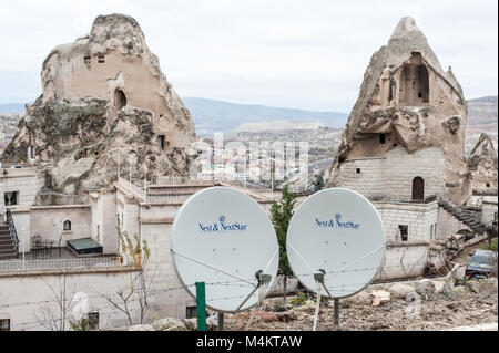Alte geschnitzte rock Häuser mit Satellitenschüsseln in Kappadokien, Türkei Stockfoto