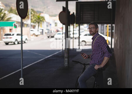 Mann mit Handy stehen auf Bürgersteig Stockfoto