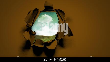 Bue Himmel und grünen Feld durch surreale Papier Loch Stockfoto