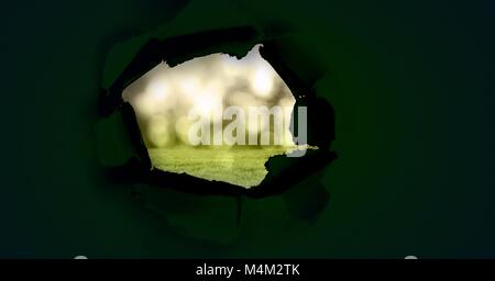 Helle grüne Natur Licht durch dunkle Papier Loch Stockfoto