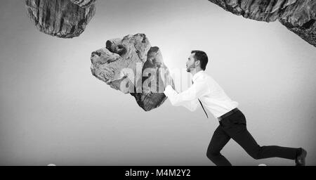 Geschäftsmann drücken surreale Felsen, die in der Luft verschoben werden Stockfoto