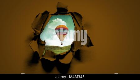 Heißluftballon schweben durch surreale Papier Loch Stockfoto