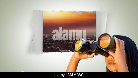 Mädchen suchen durch ein Fernglas mit Blick aufs Meer in Papier Loch Stockfoto