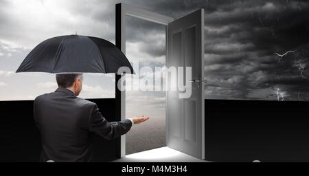 Mann mit Regenschirm und offene Tür mit surrealen Grau bewölkter Himmel Stockfoto