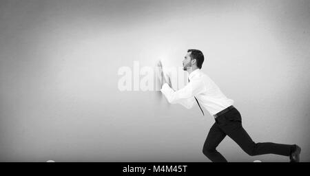 Geschäftsmann schiebt gegen die Wand Stockfoto