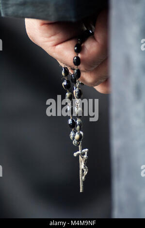 Detail der Hand des Pönitenten mit einem Rosenkranz, zählen die Perlen beim Beten. Stockfoto