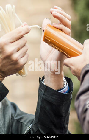 Detail der einige Hände mit einem Docht Anzünden der Kerze des Pönitenten der Bruderschaft des 'Los Estudiantes". Stockfoto