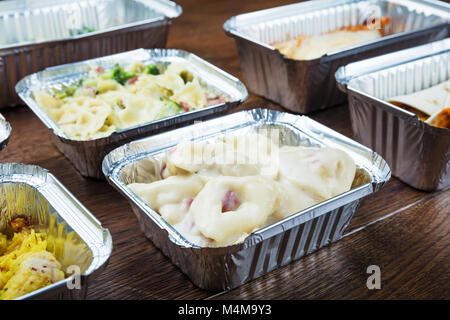 In der Nähe der Gerichte in Folie Container auf dem Tisch nehmen Stockfoto