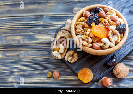 Nüsse und Trockenfrüchte in eine hölzerne Schüssel. Stockfoto