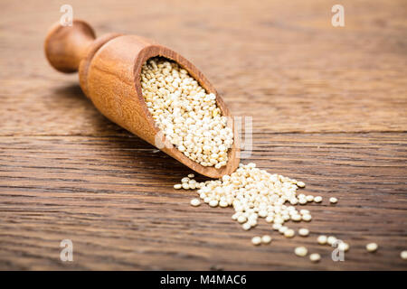 Nahaufnahme einer Raw White Quinoa Samen in hölzernen Löffel am Tisch Stockfoto