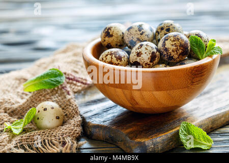 Gesprenkelte Wachteleier in eine hölzerne Schüssel. Stockfoto