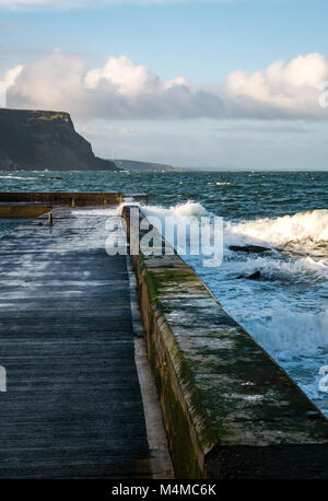 Wellen, die am Pier, Küstenort Crovie, Nordosten Schottland, Großbritannien Stockfoto