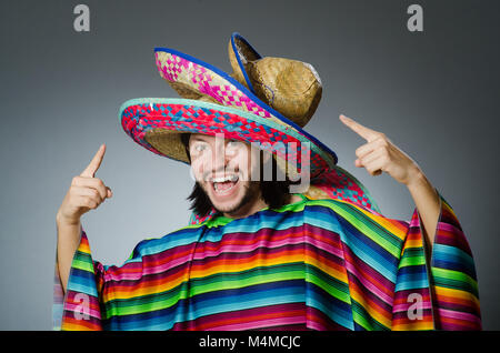 Mann in einem lebendigen mexikanischen Poncho grauen Hintergrund isoliert Stockfoto