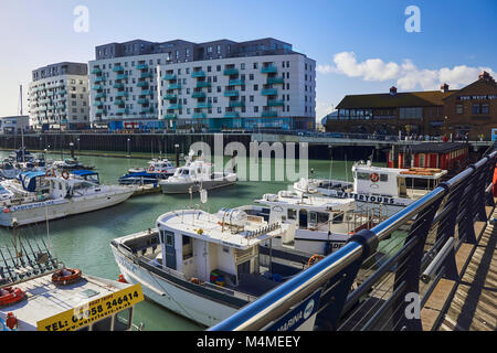 Brighton Marina Village, ein Hinweisschild auf dem Board Walk mit luxuriösen Apartments im Hintergrund ein sehr beliebter Platz in Brighton zu gehen Stockfoto