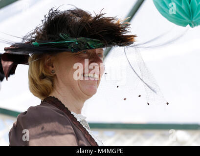 Ein schickes und teures Kleid und Hut durch die Ärzte Frau getragen in einem regionalen Kleid Stockfoto