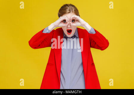 Roter Kopf Frau in Rot Anzug im Fernglas weit weit weg. Studio shot, auf gelbem Hintergrund Stockfoto