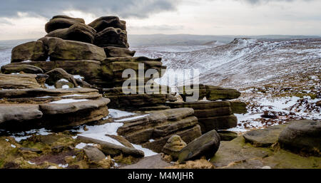 Winter Blick aus dem Verwitterten Tor an Pym Stuhl in der Nähe von Edale Richtung von Schweinen auf Kinder Scout in der Derbyshire Peak District suchen Stockfoto