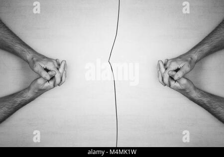 Die Hände der Männer sitzen einander gegenüber, und ein Riss in der Mitte, das Konzept des Dialogs, Uneinigkeit, Rift in Beziehungen Stockfoto