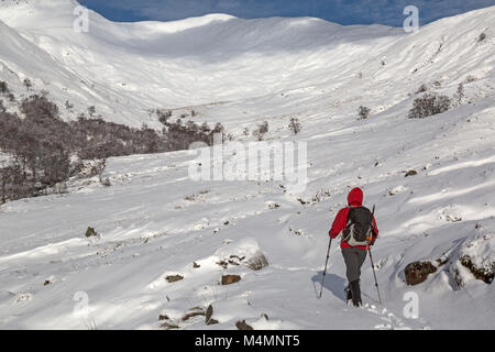 Weibliche Wanderer Richtung Stob Coire "Mamores Chàirn im Gebirge in Schottland im Winter. Schnee, den Pfad und die Berge. Stockfoto