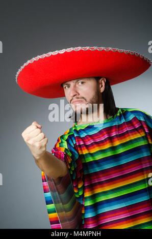 Mann in einem lebendigen mexikanischen Poncho grauen Hintergrund isoliert Stockfoto