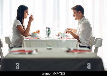 Zwei lässige junge Erwachsene ein Gespräch bei Tisch. formellen Vorschlag, im Gespräch in einem Restaurant. Der Versuch, Lebensmittel, Angebote, Special Menü. Glückliches Paar Essen Stockfoto