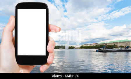 Travel Concept - touristische Fotos Binnenalster (Binnenalster) mit Brunnen in der Stadt Hamburg im September auf dem Smartphone mit ausgeschnittenen Bildschirm für Stockfoto