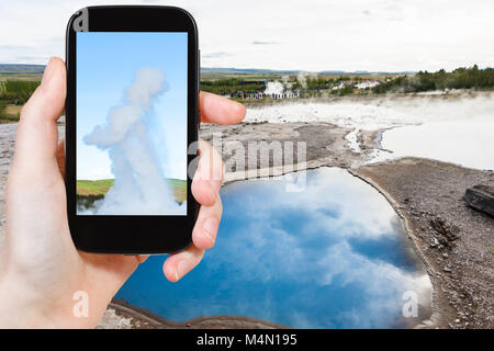 Travel Concept - touristische Fotos pool Der Geisyr (Der Große Geysir) im Haukadalur Hot Spring in Island im September auf dem Smartphone Stockfoto