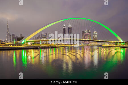 Brücke über Wasser Kanal mit Reflexion und Skyline von Dubai, Vereinigte Arabische Emirate Stockfoto