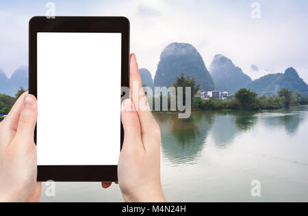 Travel Concept - Touristische photograps Wasser des Yulong und Jinbao Flüsse und Karst Peaks in Yangshuo County in China im Frühjahr auf Tablet mit ausgeschnittenen scr Stockfoto