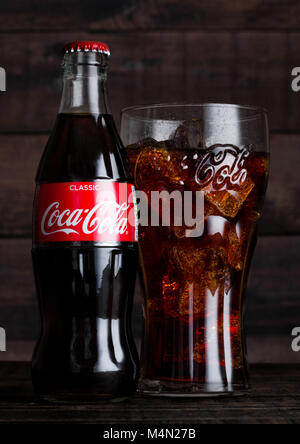 LONDON, UK, 14. Februar 2018: Original Glas und Flasche Coca Cola trinken mit Eis auf Holz- Hintergrund. Das Getränk wird produziert und hergestellt von Stockfoto