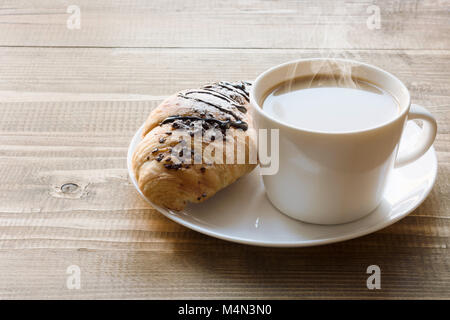 Frisch gebackene Croissants und Schokolade Tasse Kaffee auf Holzbrett. Frühstück Konzept. Kopieren Sie Platz. Stockfoto