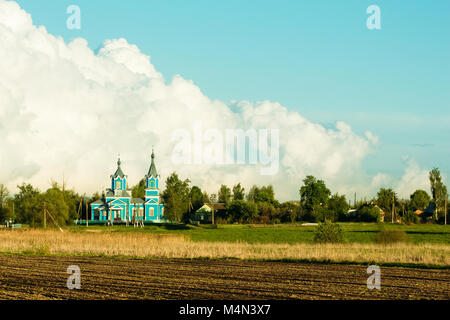 Krasnyy Partizan, dobrush Bezirk, Region Gomel, Belarus. Alte hölzerne Kirche der Geburt der Jungfrau in einer Landschaft bei Sonnenuntergang Stockfoto