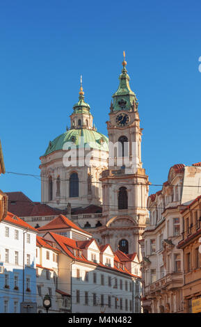 Prag - 10. Juli: Die Kuppel und Glockenturm der St.-Nikolaus-Kirche mit umgeben die Gebäude nach Sonnenaufgang am 10. Juli 2017 in Prag, Tschechische Repub Stockfoto