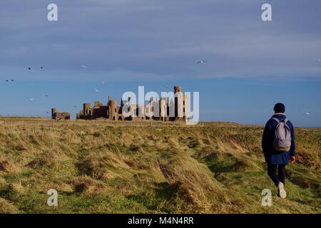 Wanderer auf dem Weg zur Ruine der Neuen Slains Castle an einem sonnigen Wintertag. Cruden Bay, Aberdeenshire, Schottland, Großbritannien. Feb., 2018. Stockfoto