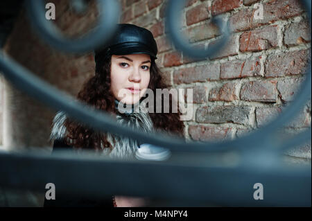 Curly mexikanische Mädchen in Leder und Plastik Tasse Kaffee zur Hand gehen an Straßen der Stadt. Stockfoto