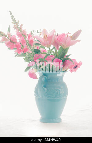 Rosa Blumenstrauß in einer blauen Vase mit weißem Hintergrund Stockfoto